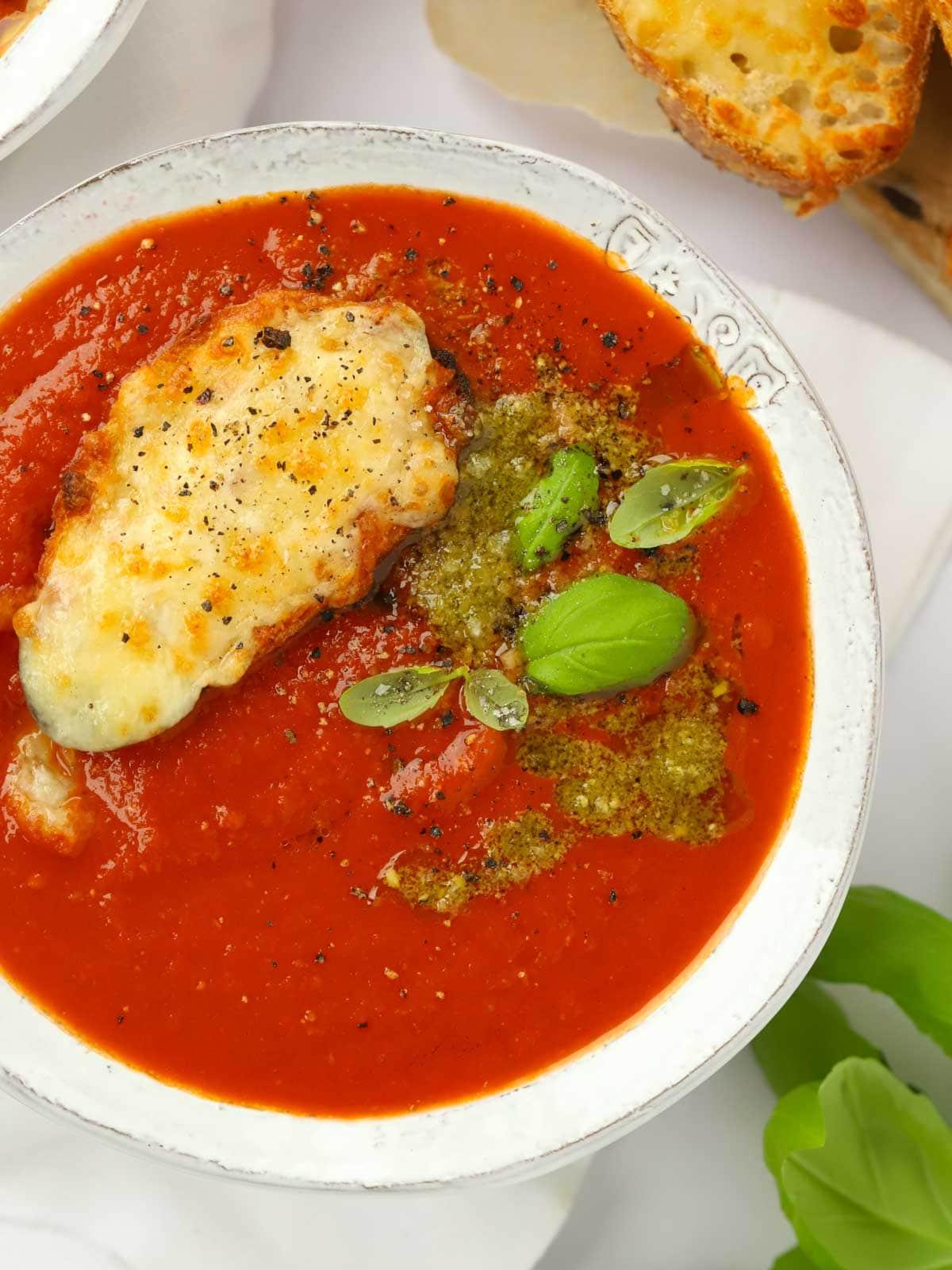 Facile Zuppa di Pomodoro {Ingredienti da dispensa} 2 Una deliziosa ciotola di zuppa di pomodoro ricca e facile, guarnita con pesto e accompagnata da toast al formaggio.