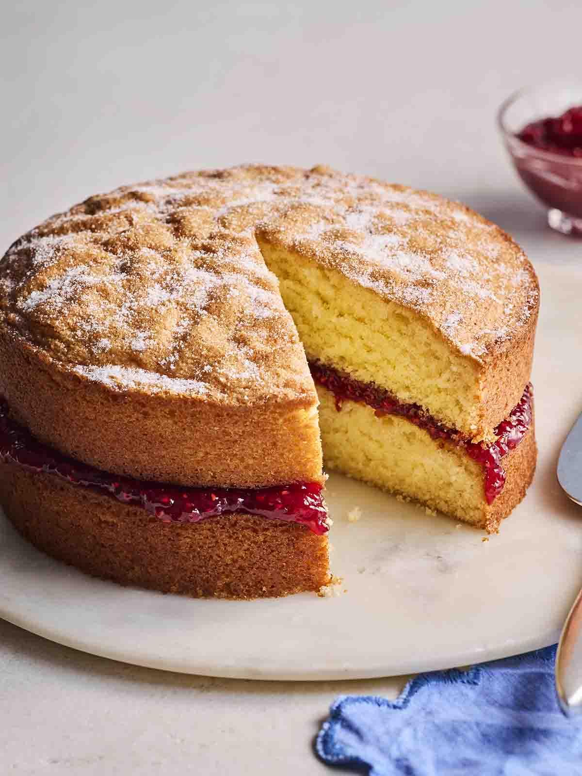 Torta Victoria Classica 2 Un pezzo mancante di Torta Victoria Sponge fatta in casa su un piatto.