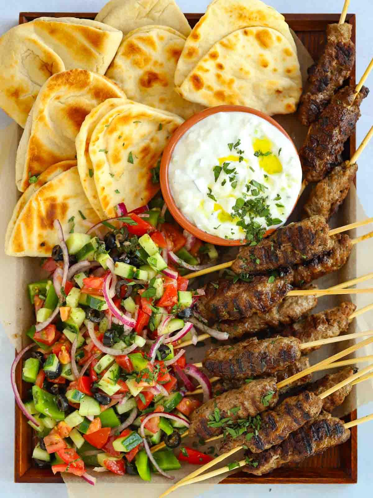 Facili Kofta di Agnello {con Tzatziki} 2 Ricetta Kofta di agnello con carne macinata e tzatziki, su un vassoio con piadine.