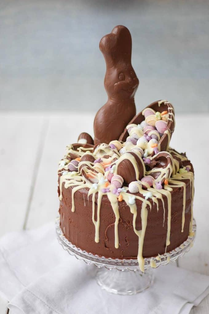 Torta al Cioccolato di Pasqua 2 La Torta al Cioccolato Pasquale Definitiva! Un'esplosione di dolcetti di Pasqua in questa torta al cioccolato decadente, deliziosa e ricca. Decorata con uova Cadbury's Creme Eggs, Mini Eggs, glassa di cioccolato bianco, coniglietti e uova al caramello. Cosa si può chiedere di più da un dolce pasquale?!