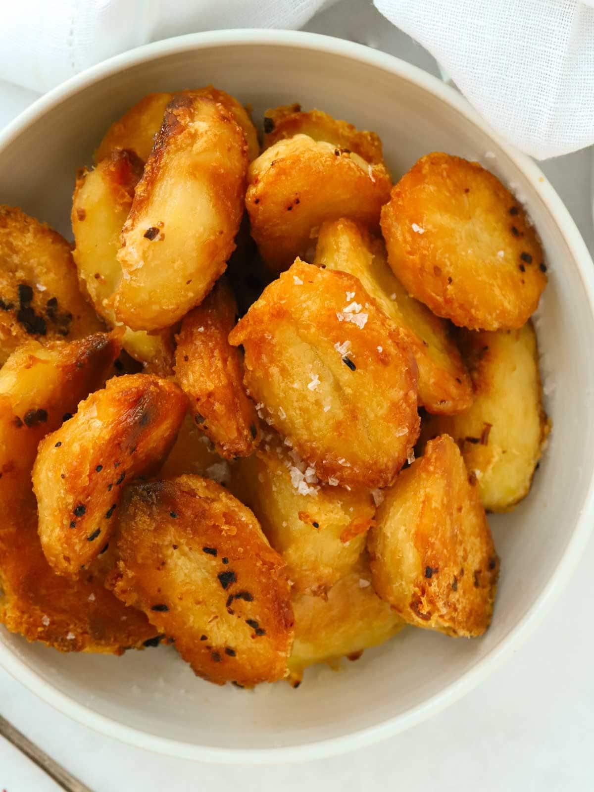 **Patate Arrosto {Le Migliori di Sempre, Ricetta Facile!}** 2 Primo piano di una ciotola di deliziose patate arrosto dorate. Questa è una ricetta facile e infallibile.