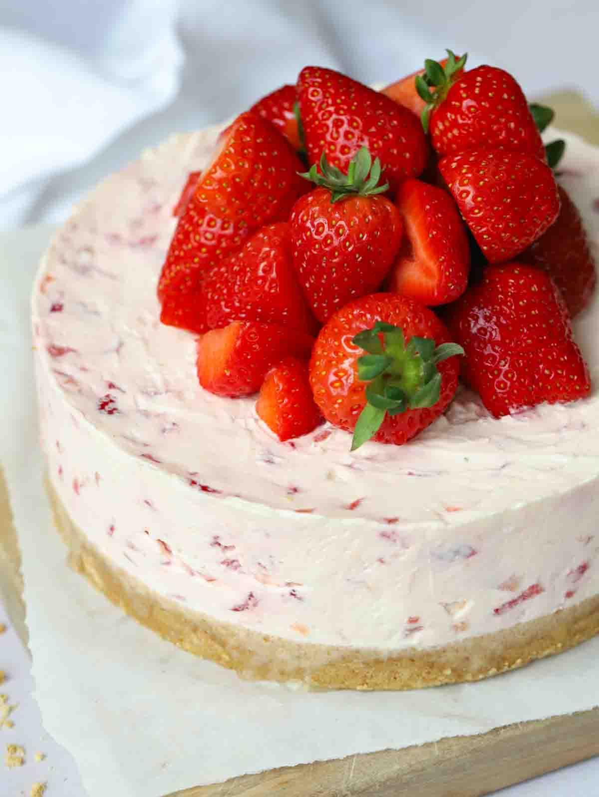 Cheesecake con fragole disposte abbondantemente sulla parte superiore.