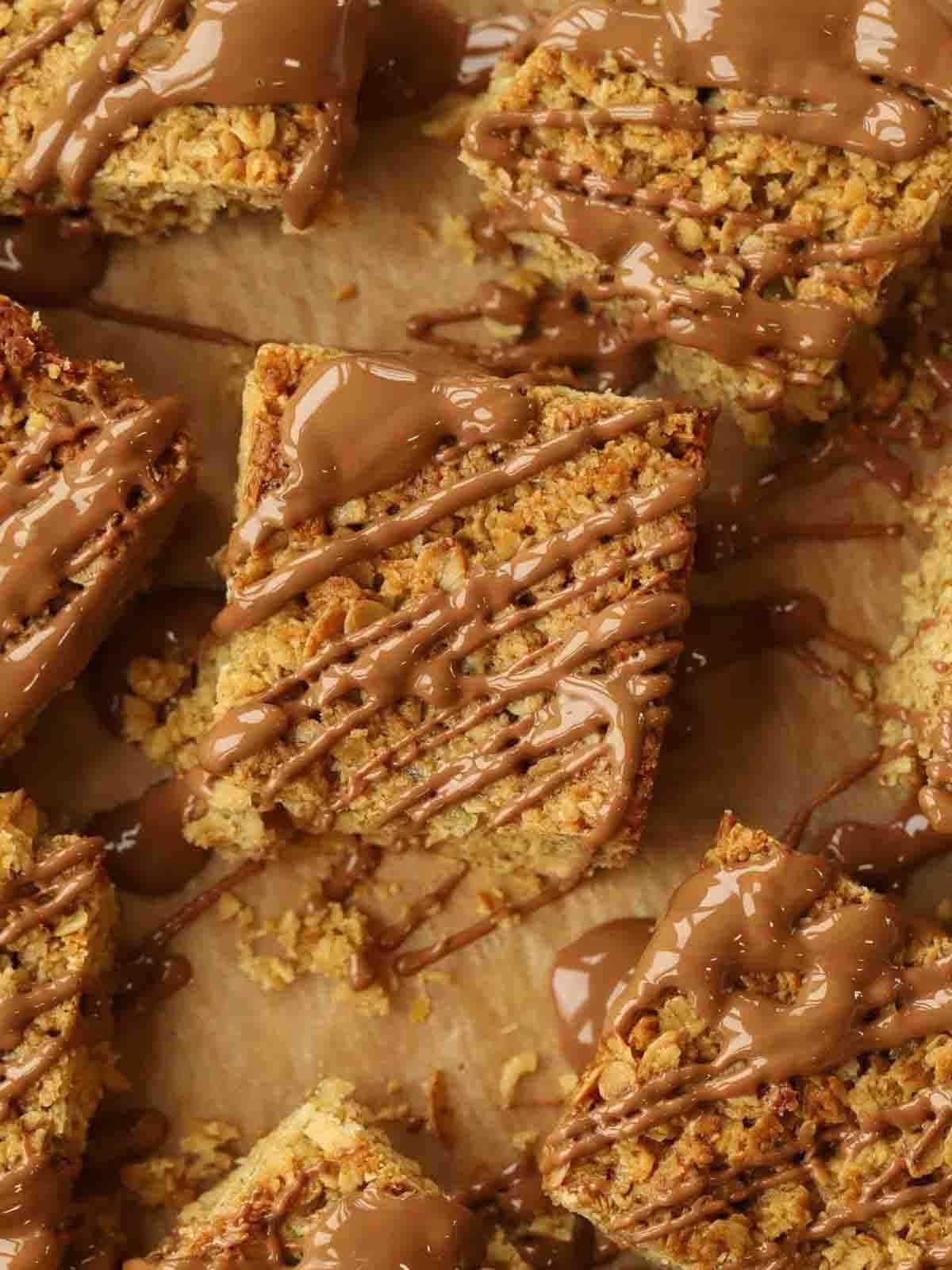 Pancakes Facili {Ricetta Infalibile!} 2 Quadrati di flapjack ricoperti di cioccolato fuso su carta da forno.