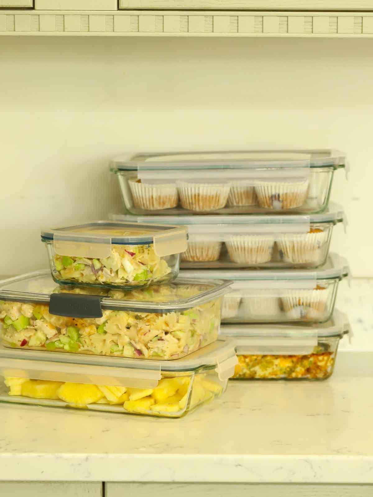 **Organizzazione Domenicale 7: Pre-preparazione Pasti** 2 Contenitori per meal prep in vetro su un piano di lavoro, pieni di cibo preparato in anticipo per la settimana.