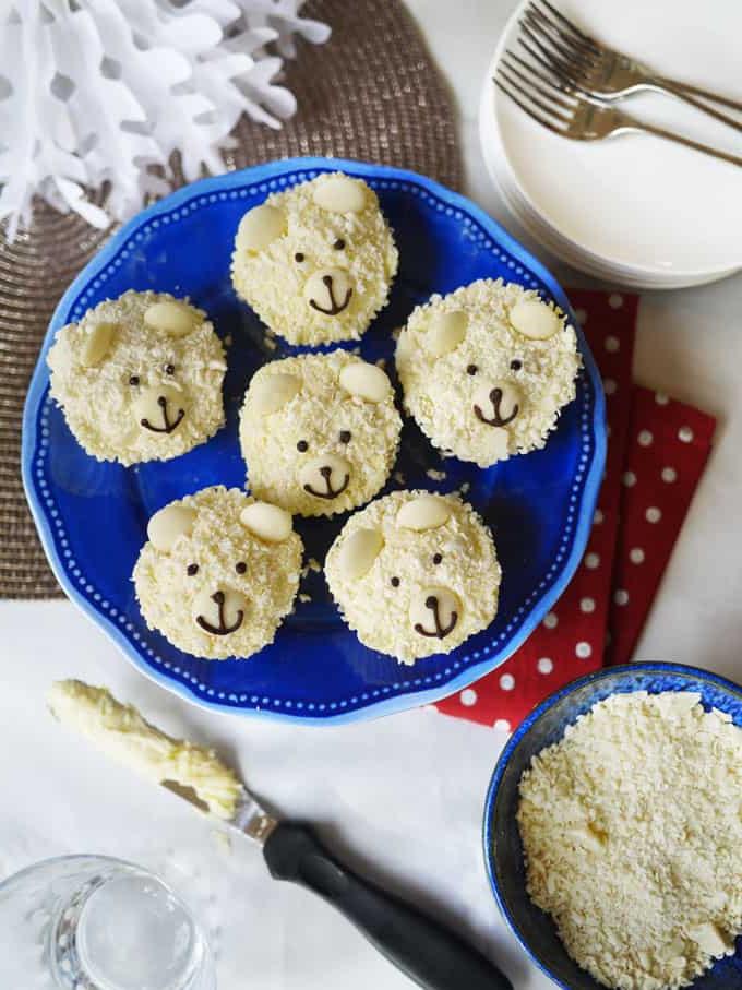 Cupcakes Orso Polare {Ricetta Facilissima!} 2 Un tavolo festivo con un piatto blu contenente cupcake orso polare pronti da mangiare.
