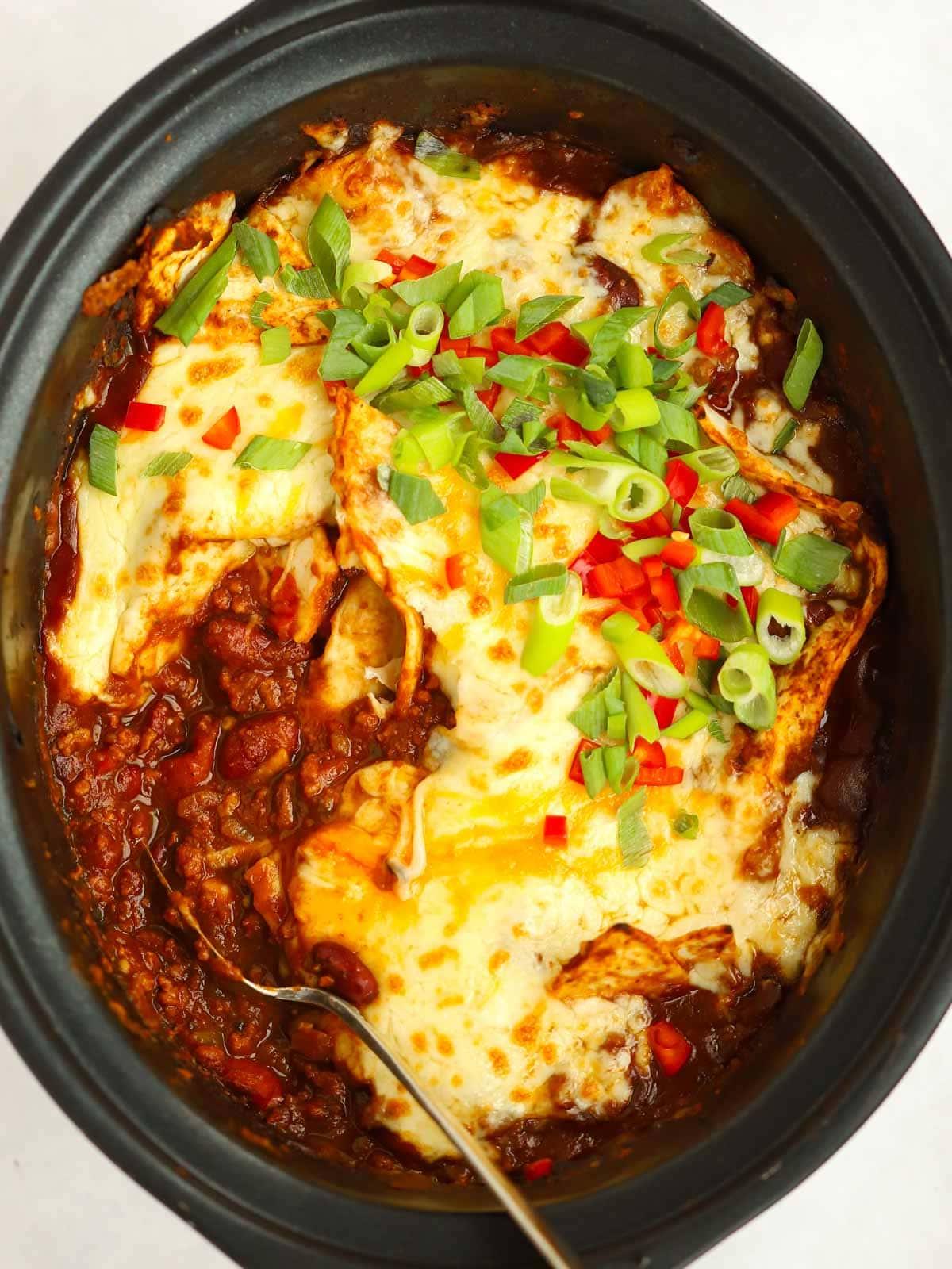 Enchiladas di Manzo in Slow Cooker 2 Formaggio fuso con enchiladas di manzo in una slow cooker, pronte per essere servite.
