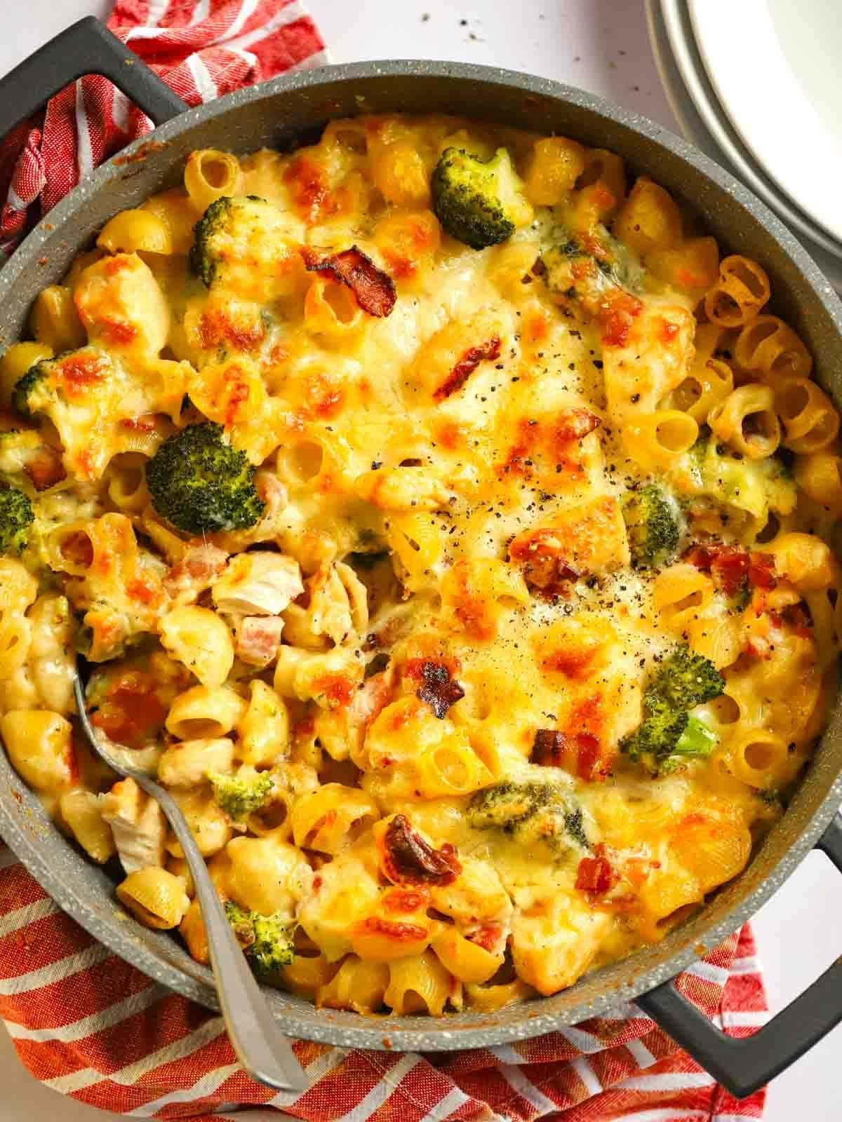 Pasta al Forno con Pollo e Pancetta {Così Facile!} 2 Un'ampia teglia su un tavolo piena di Pasta al Forno con Pollo e Pancetta, con formaggio gratinato in cima, pronta per essere servita.