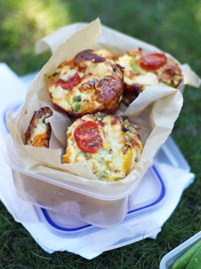 **Ricetta Mini Quiche Senza Crosta** 2 Mini Quiche Senza Crosta in una scatola sull'erba, pronte per un allegro pic-nic all'aperto.