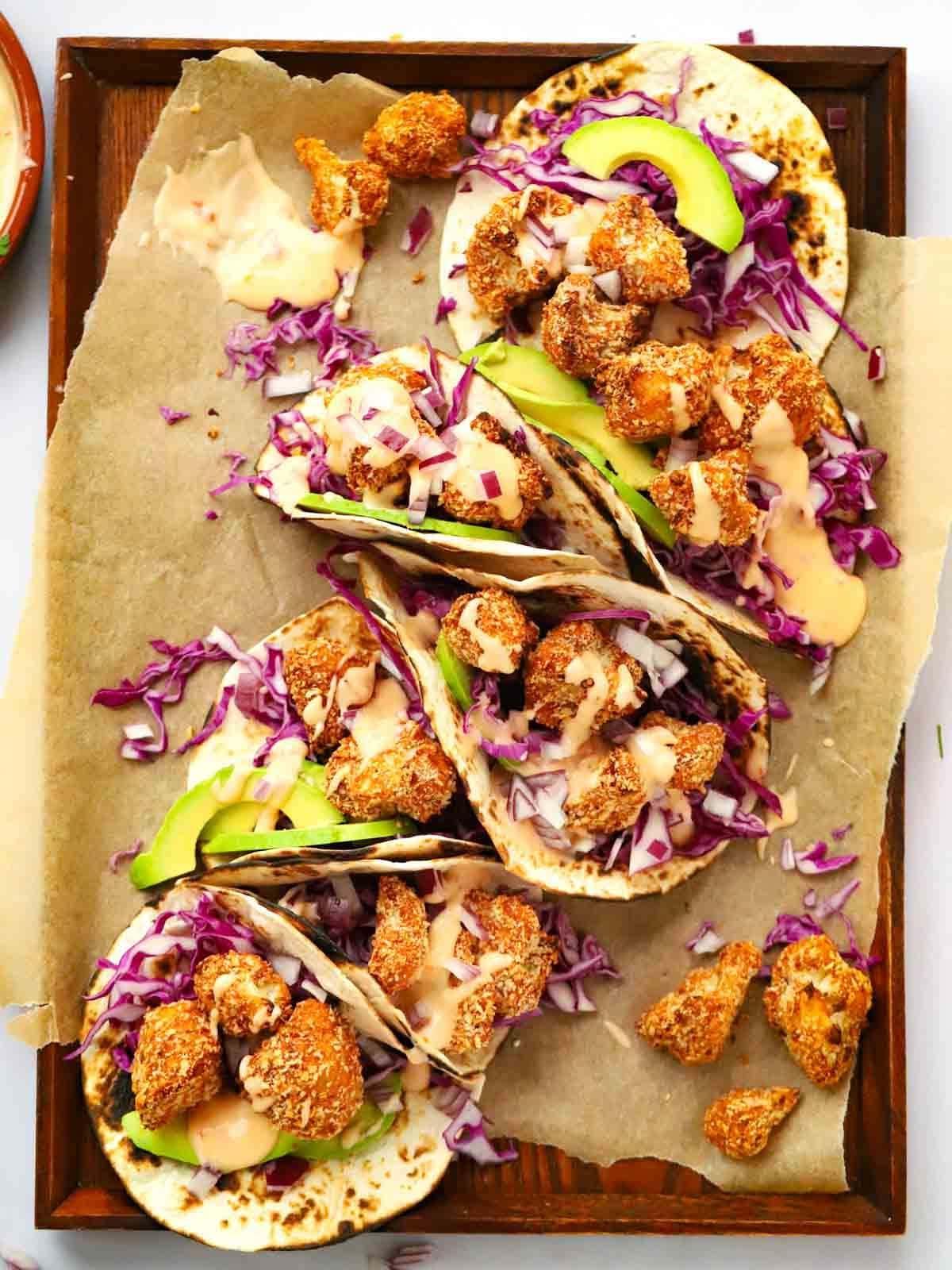 Tacos di Cavolfiore Croccante (con Maionese al Peperoncino Dolce) 2 Cauliflower Tacos placed together on a tray, ready for sharing.