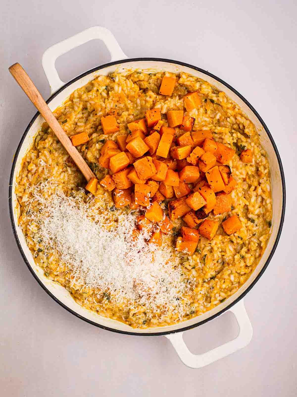 **Risotto di Zucca {Al Forno o Tradizionale}** 14 Una padella piena di risotto alla zucca cotto, con cubetti di verdura sopra e parmigiano grattugiato da mescolare.