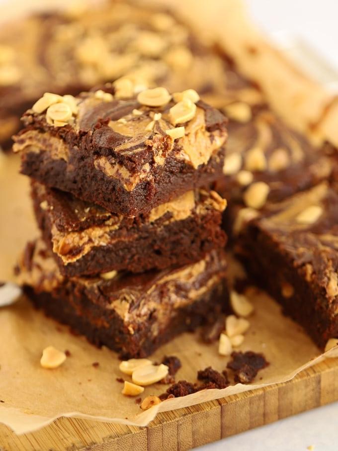 Pila di quadrati di brownie guarniti con arachidi.