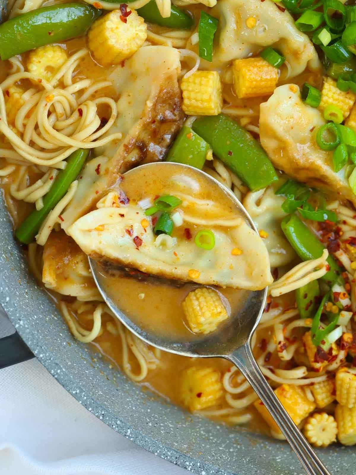 Un cucchiaio che serve un boccone di Zuppa di Gyoza.