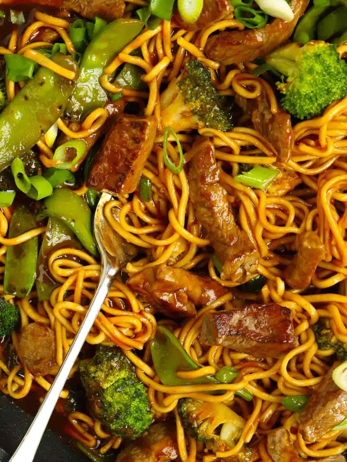 Manzo Glassato e Noodles {Monopadella} 3 Una forchetta infilata nei noodles, con bistecca e verdure in mezzo.