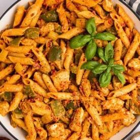 Una ciotola di pasta Cajun al pollo in una sola pentola, pronta per essere servita, con basilico in cima.
