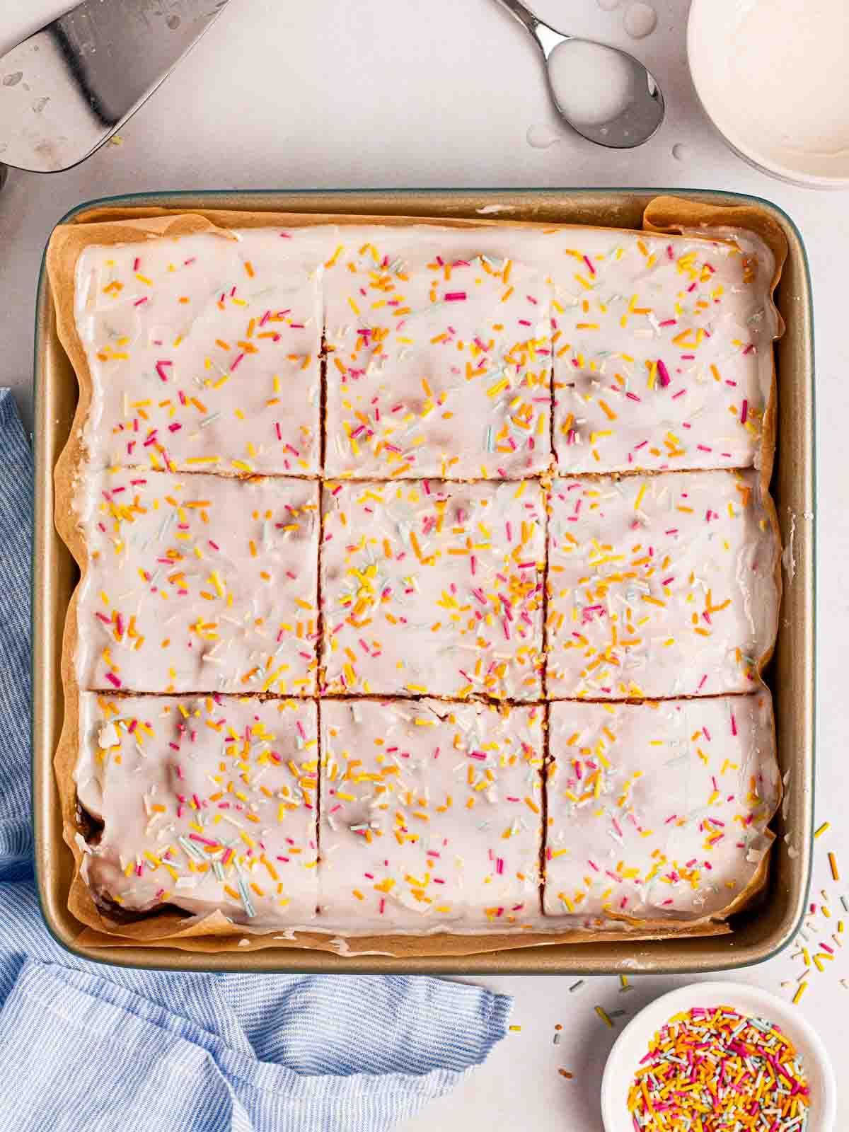 Torta Scolastica {Ricetta Facile!} 3 Una teglia quadrata piena di una semplice Torta della Scuola su un tavolo con zuccherini sopra.