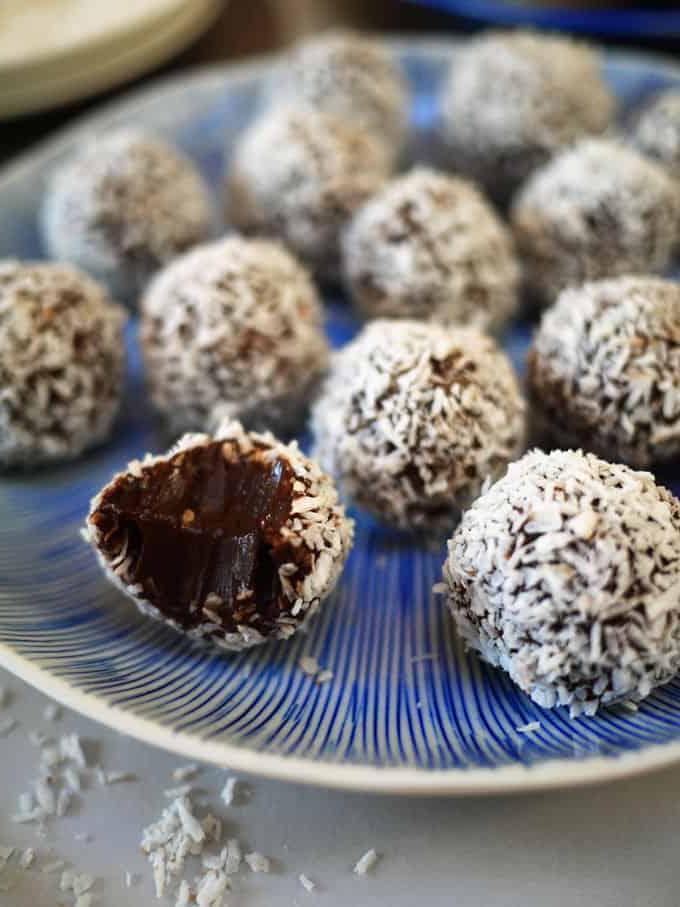**Tartufi al Cioccolato Palline di Neve {Ricetta Facile}** 3 Un primo piano di tartufi di cioccolato fatti in casa, uno con un morso.