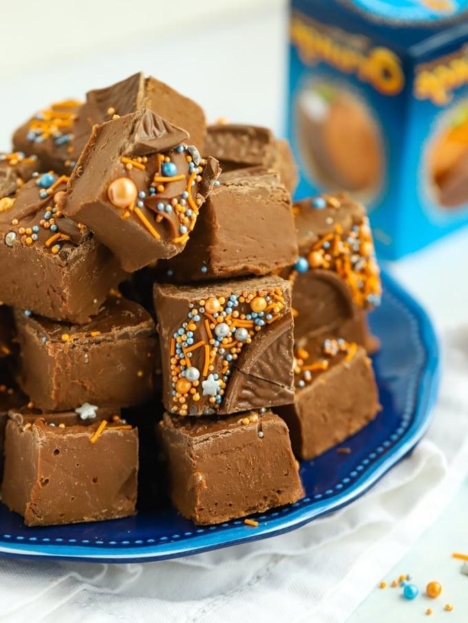 Fudge all'arancia e cioccolato {Solo 2 Ingredienti!} 3 Quadretti di Terry's Chocolate Orange Fudge, impilati su un piatto, pronti per essere gustati.