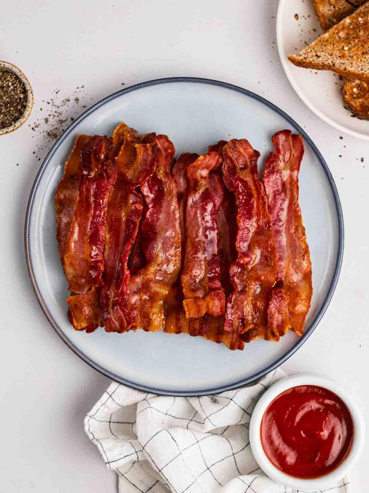 Bacon Perfetto nella Friggitrice ad Aria 3 Un piatto pieno di pancetta tesa cotta, preparata nella friggitrice ad aria.