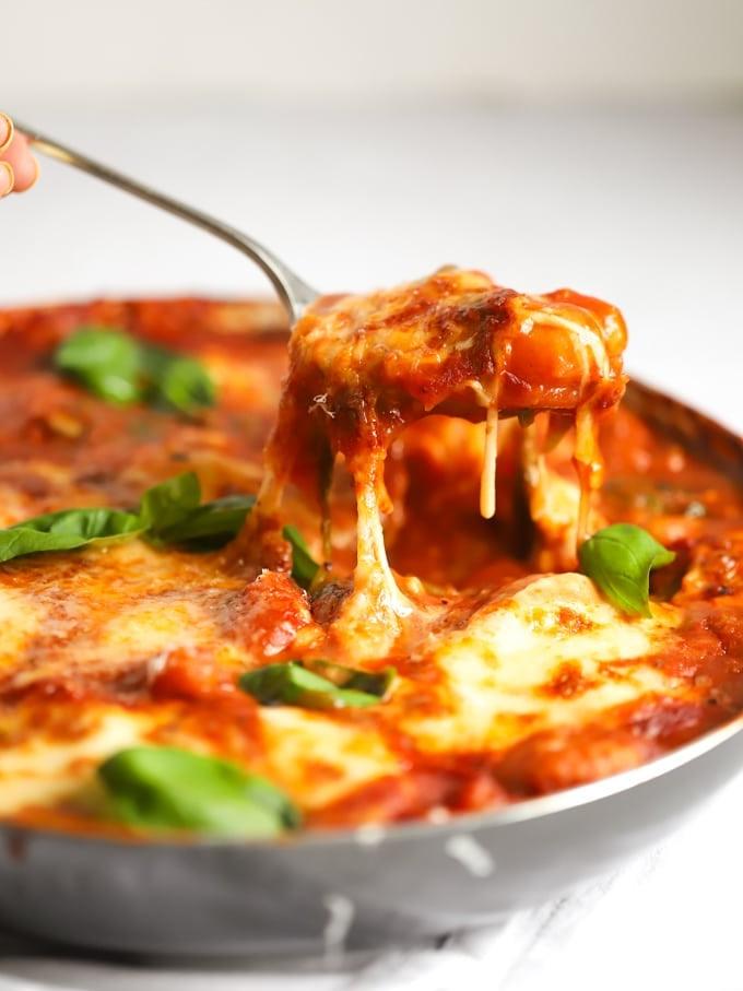Gnocchi Facili al Forno 3 Gnocchi al forno guarniti con mozzarella e basilico, sollevati dalla teglia.