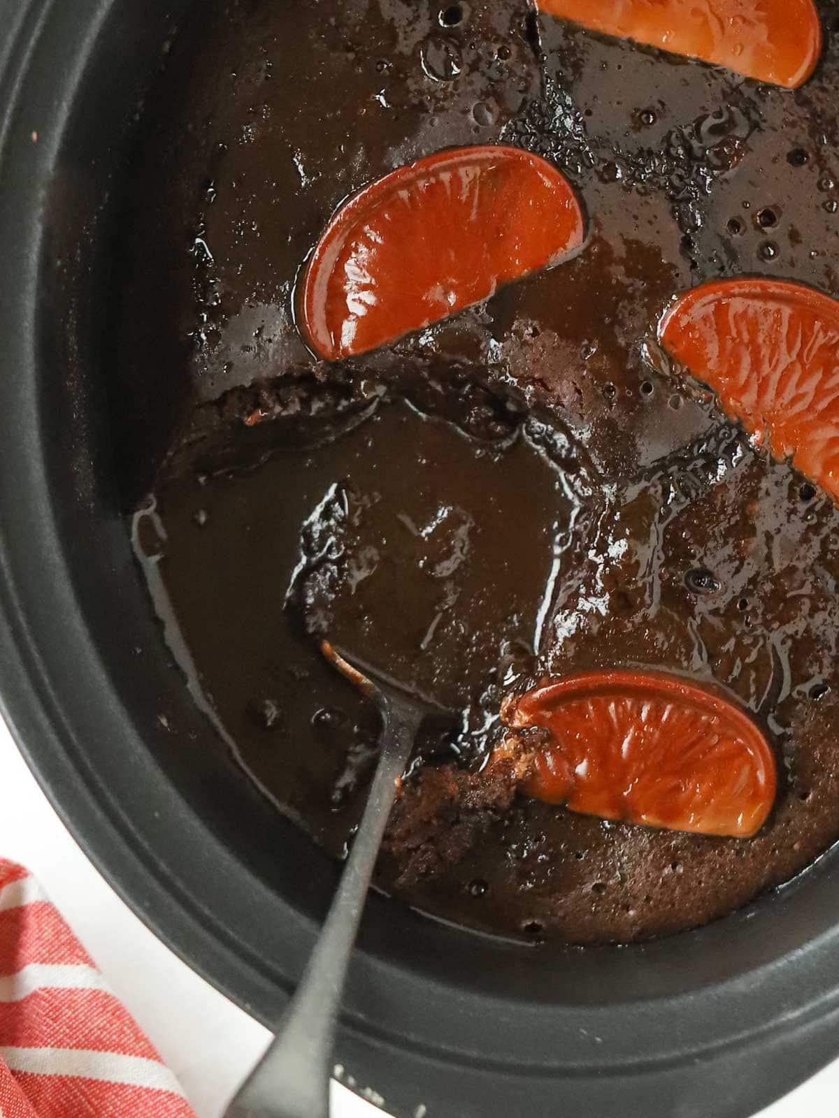 Pudding al Cioccolato e Arancia a Cottura Lenta 3 Close up of slow cooker pan with chocolate orange pudding inside.
