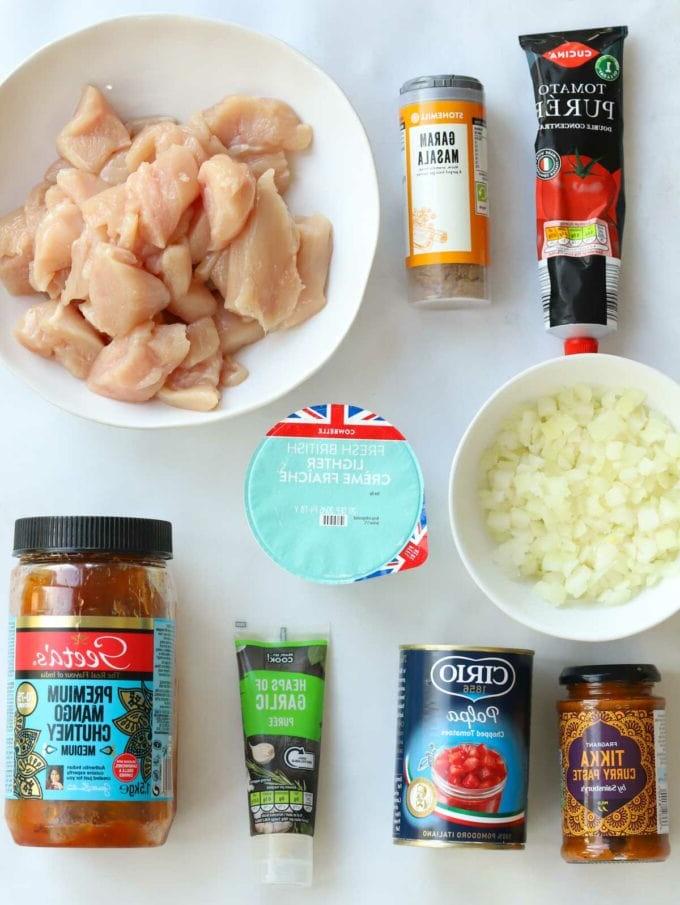 Gli ingredienti disposti nelle loro confezioni, mostrando ciò che serve per la ricetta del pollo tikka masala in slow cooker.