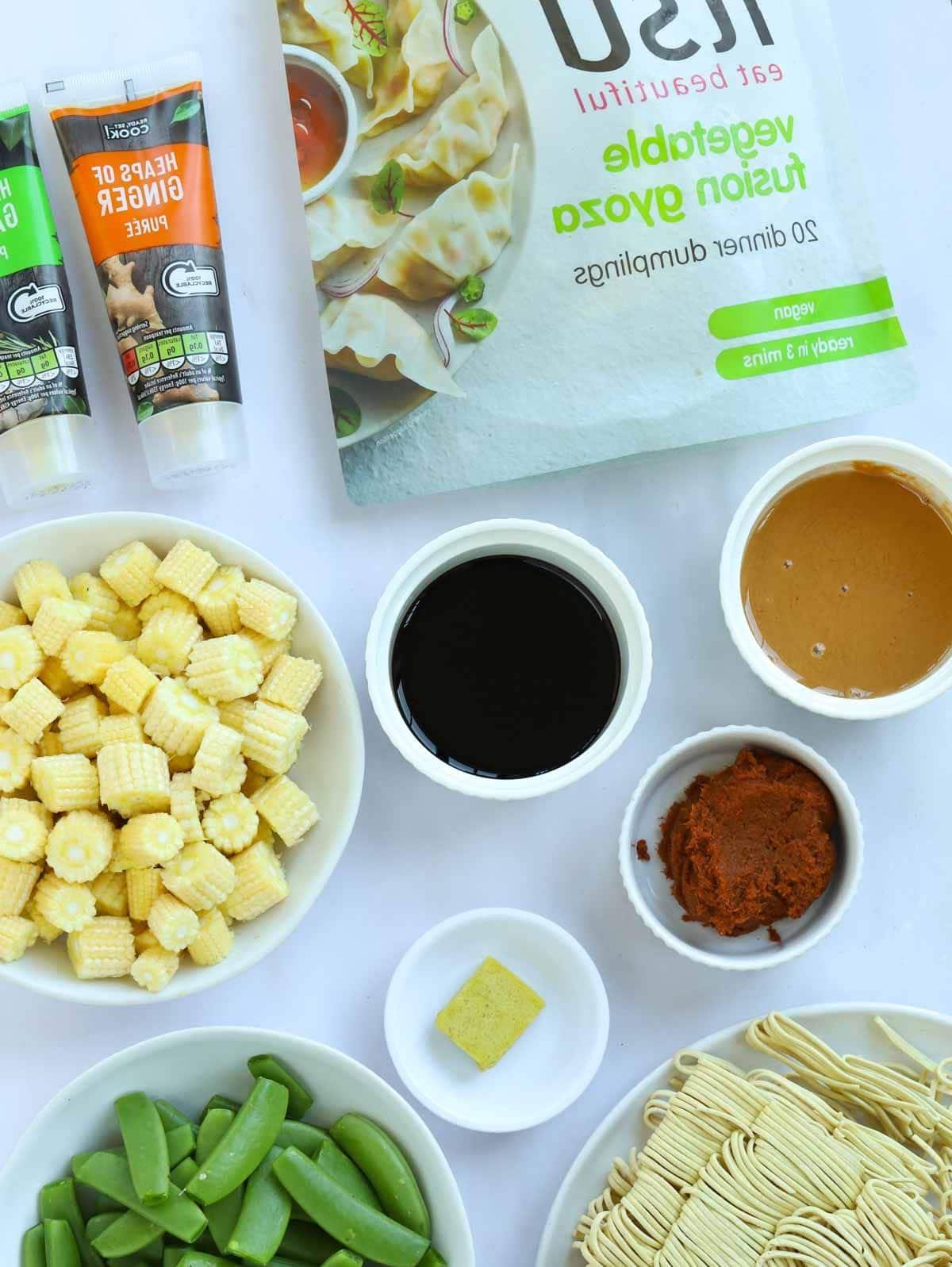 Ingredienti per una ricetta di Zuppa di Gyoza disposti su un tavolo.