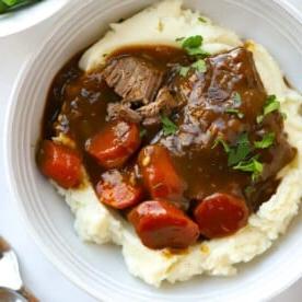 Menù di San Valentino o delle Amiche 4 Deliziosa bistecca brasata con carote in salsa su un letto di purè di patate.