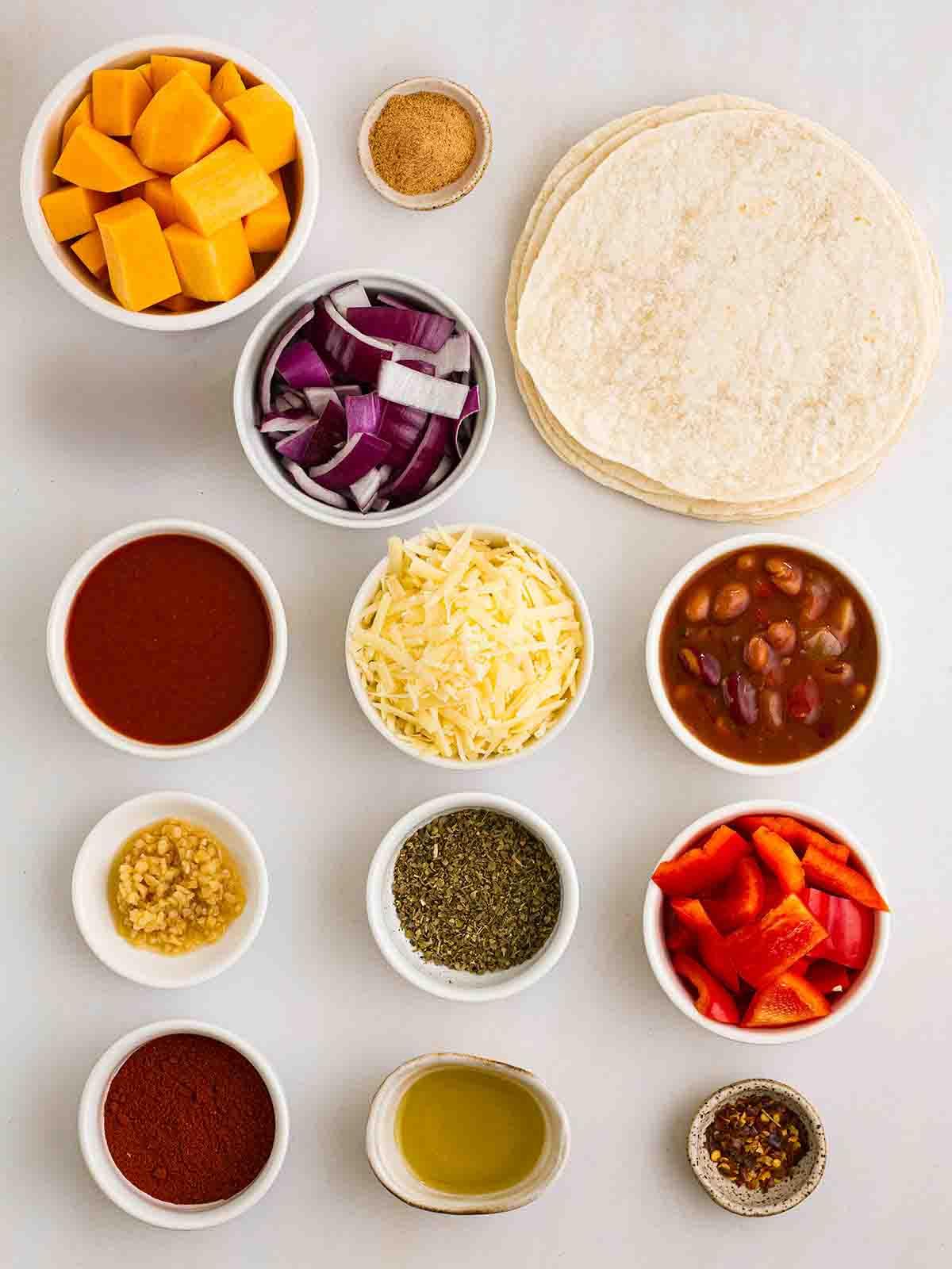 Enchiladas Vegetariane con Zucca Violina 4 Gli ingredienti per le Enchiladas Vegetariane disposti su un piano di lavoro.