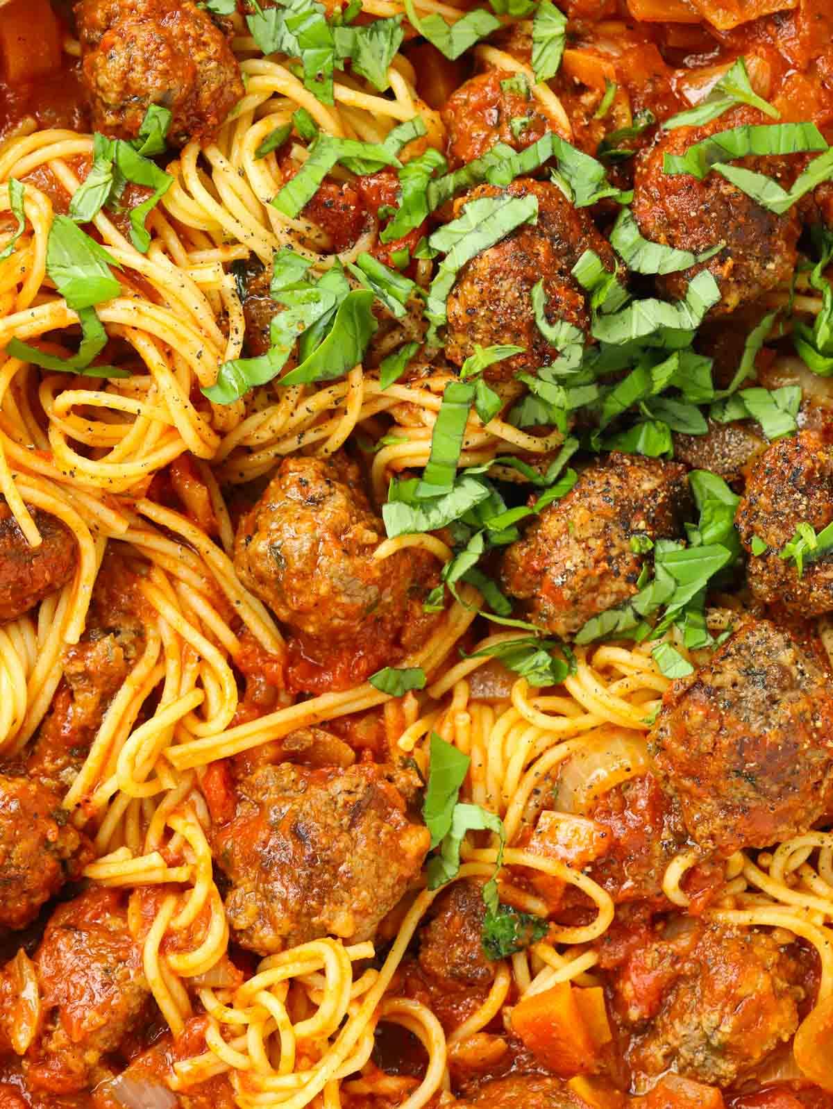 primo piano di polpette fatte in casa mescolate con sugo e spaghetti