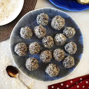 **Tartufi al Cioccolato Palline di Neve {Ricetta Facile}** 4 Una vista dall'alto di un piatto blu con tartufi di cioccolato fatti in casa, ricoperti di cocco grattugiato.