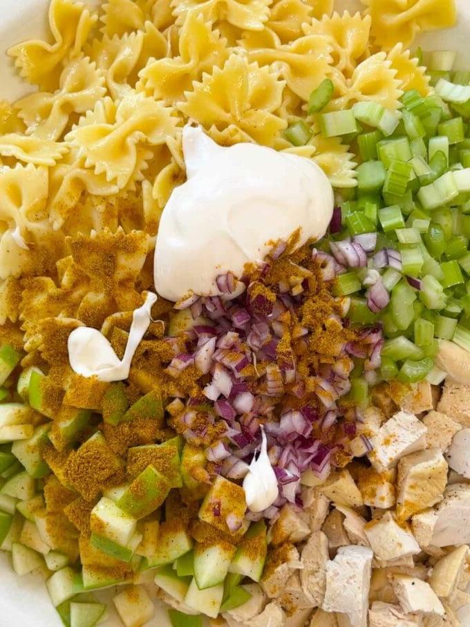 Insalata di Pasta al Pollo {Pasto da 15 Minuti} 4 Una ciotola con gli ingredienti per l'insalata di pasta con pollo, pronti per essere mescolati.
