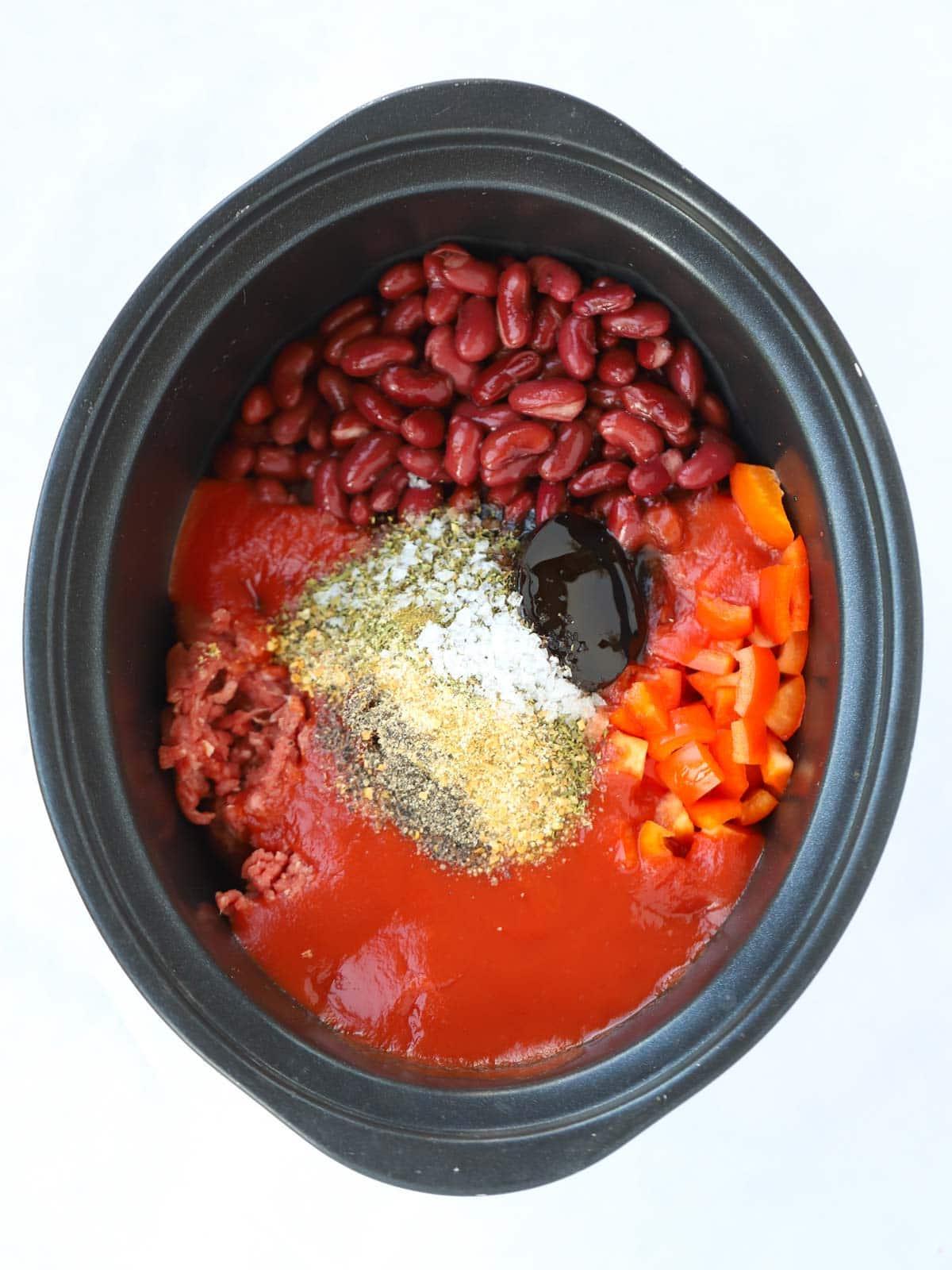 Enchiladas di Manzo in Slow Cooker 4 Ingredienti crudi per enchiladas di manzo nella pentola della slow cooker, pronti per essere cotti.