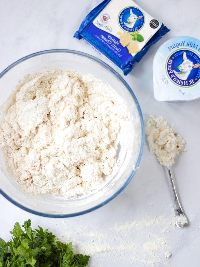 Foto dall'alto di una ciotola di impasto facile per focaccia, yogurt di capra e formaggio di capra.