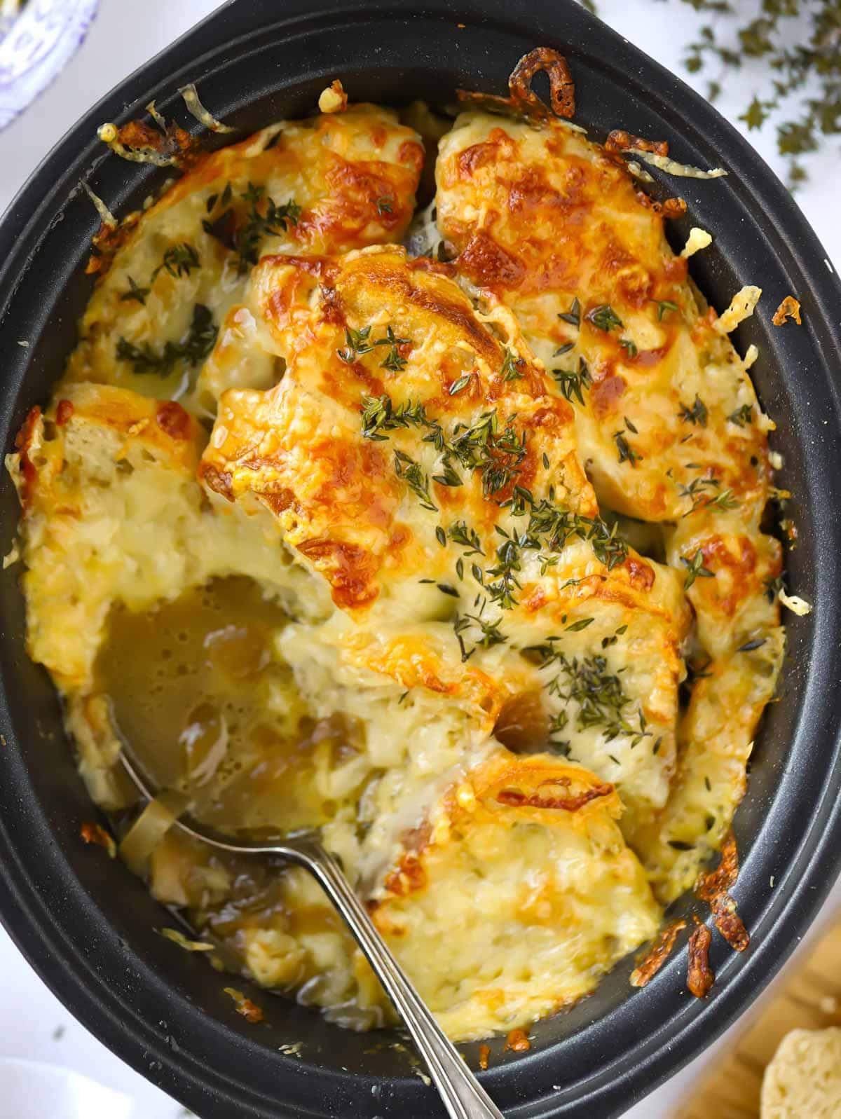 zuppa di cipolle francese primo piano con crosta di formaggio croccante in slow cooker