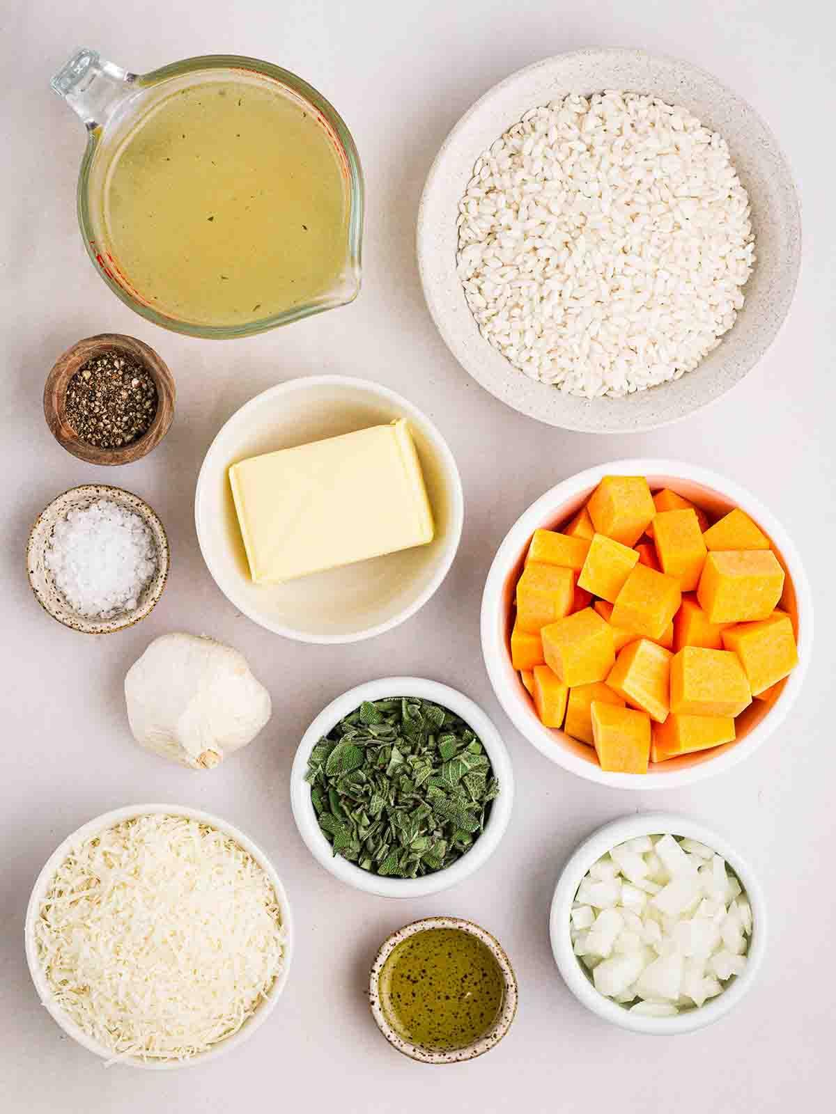 **Risotto di Zucca {Al Forno o Tradizionale}** 4 Gli ingredienti per un Risotto alla Zucca disposti in ciotole su un bancone bianco.
