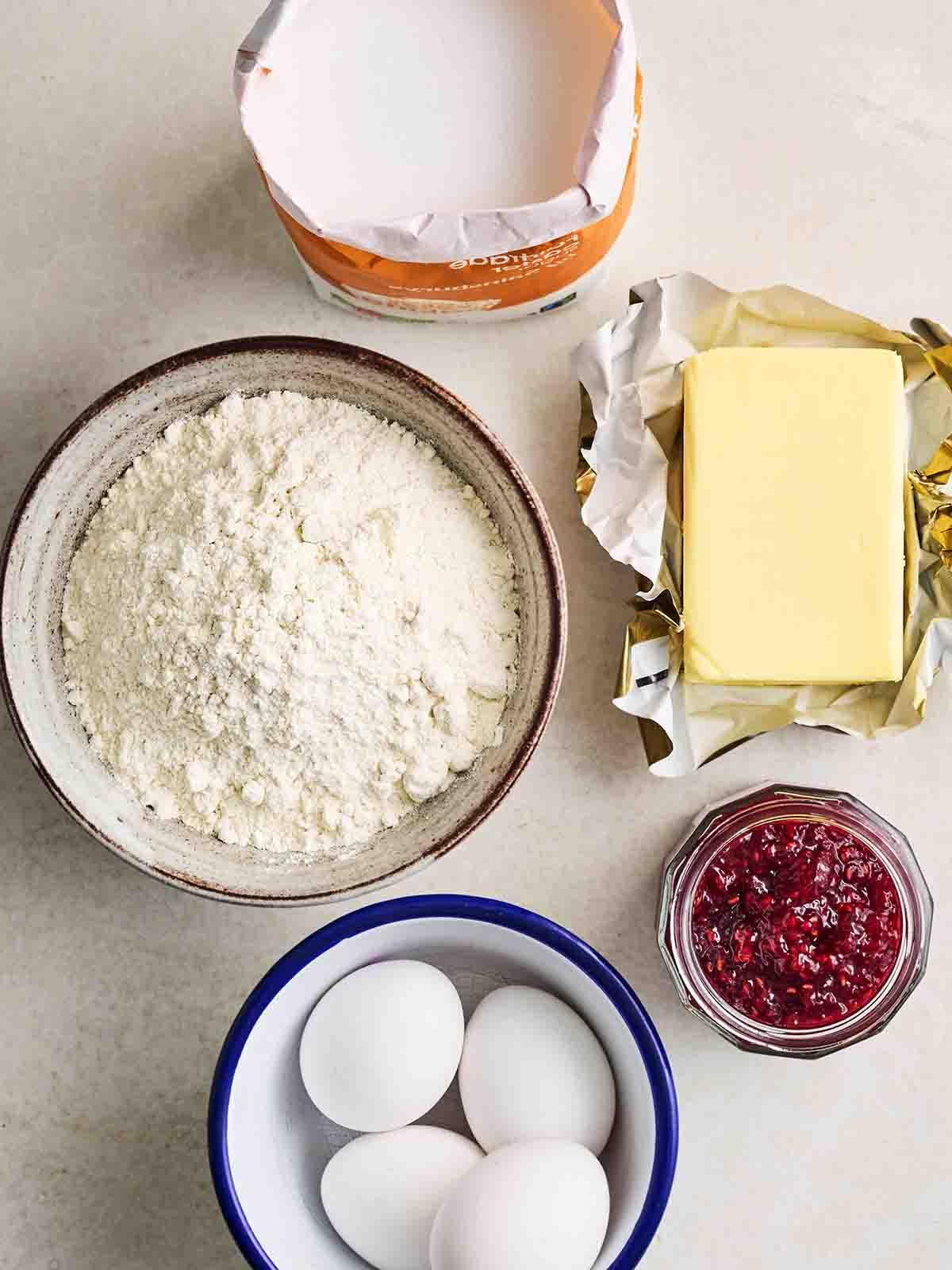 Torta Victoria Classica 4 Gli ingredienti per preparare una torta Victoria Sponge disposti su un piano di lavoro.