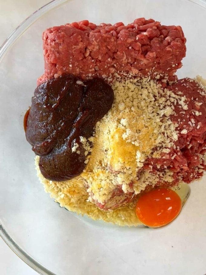 Ricetta Facile Polpettone {con Ricca Salsa di Pomodoro} 5 Ingredienti crudi in una ciotola per una ricetta facile di polpettone, passaggio 1.