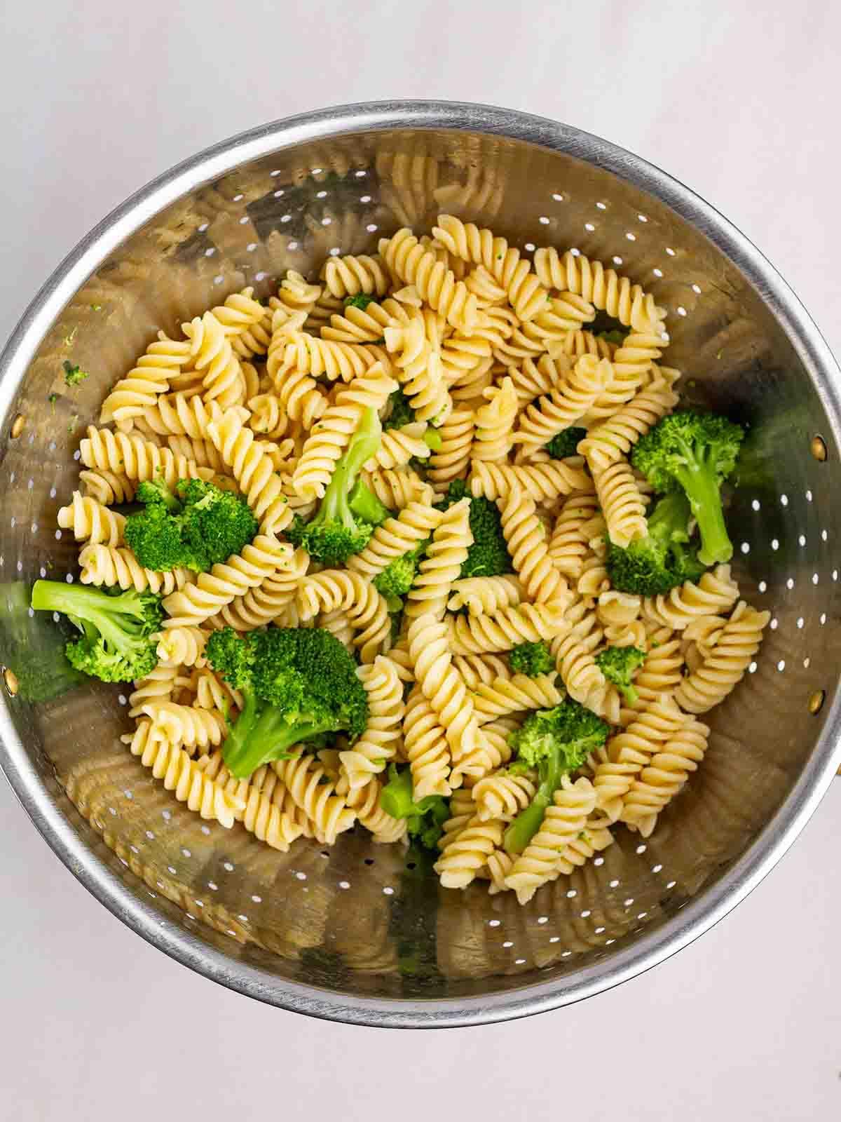 Pasta e broccoli cotti scolati in uno scolapasta.