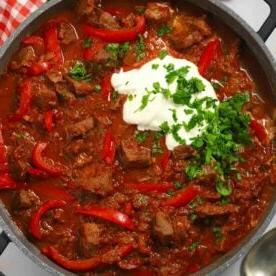 Primo piano di una pentola piena di goulash di manzo cotto lentamente.