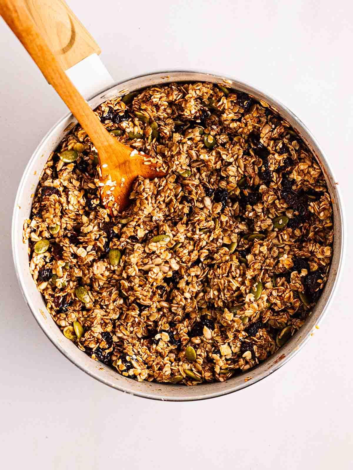 Barrette di Granola {Ricetta Facile!} 5 Avena, semi e frutta secca mescolati in padella per il passaggio 2 nel processo di preparazione delle barrette di granola.