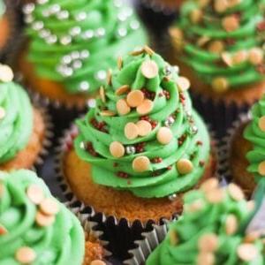 Cupcakes di Natale 5 Una teglia di Cupcakes di Natale con glassa a forma di alberi di Natale, con zuccherini per palline.