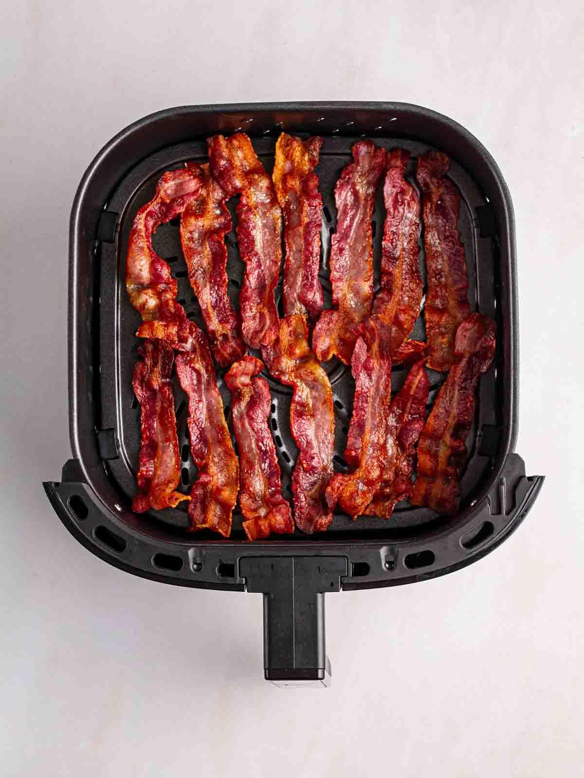 Bacon Perfetto nella Friggitrice ad Aria 5 Una friggitrice ad aria con 14 strisce di pancetta tesa cotta e croccante.