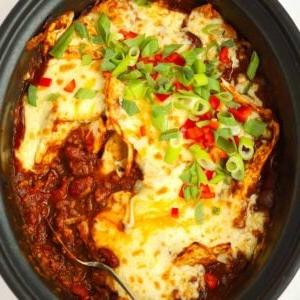Enchiladas di Manzo in Slow Cooker 5 Una pentola slow cooker piena di enchiladas di manzo cotte con formaggio fuso in cima.