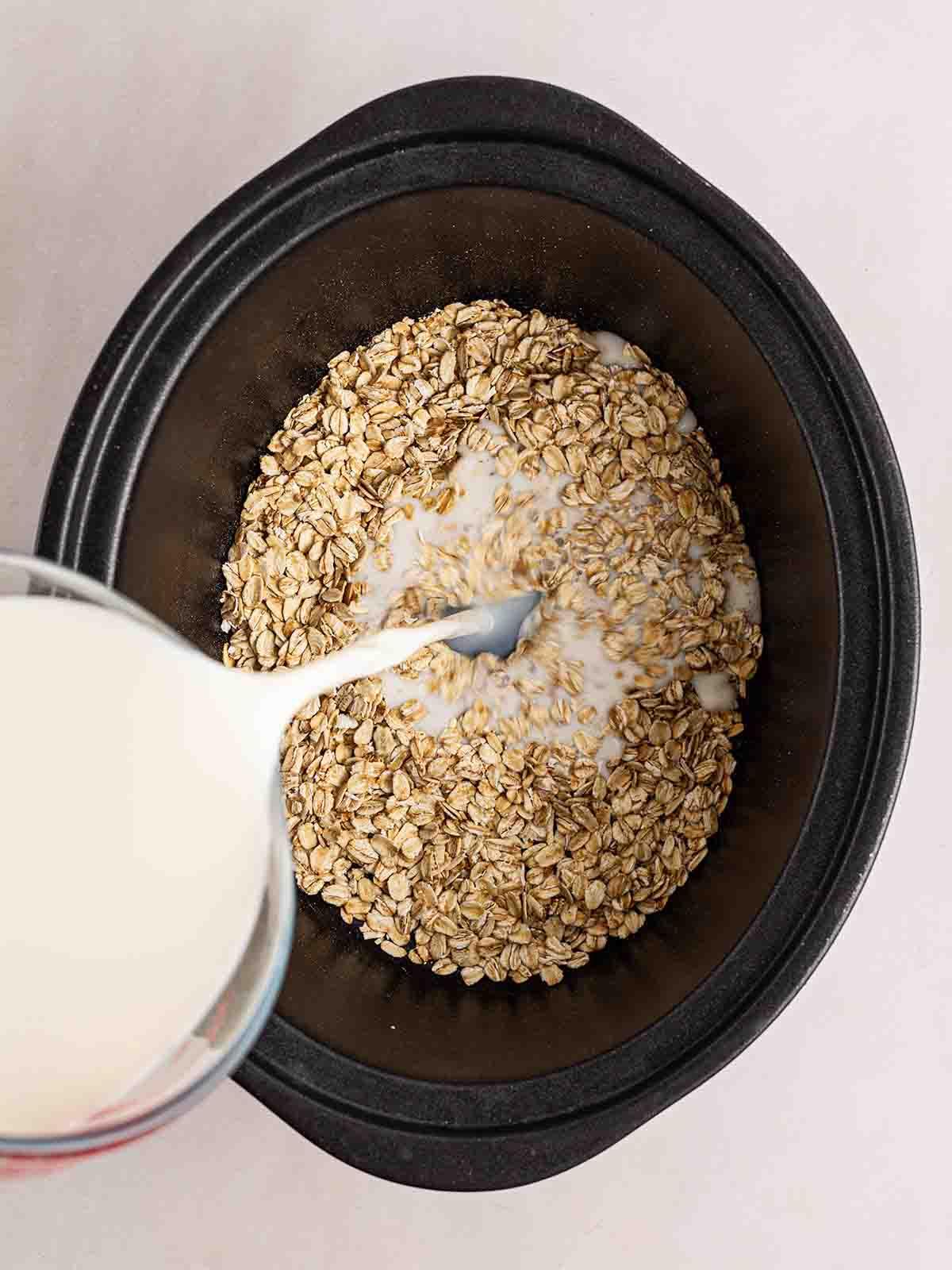 Porridge a cottura lenta 5 Una pentola slow cooker riempita di avena, con il latte versato, pronta per fare il Porridge in Slow Cooker.