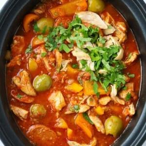 Stufato di Pollo e Chorizo a Cottura Lenta 5 Una grande pentola slow cooker piena di spezzatino di pollo e chorizo in stile spagnolo, con olive e peperoni.