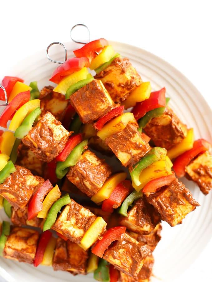 Facile Paneer Tikka {Per Griglia, Forno o Barbecue} 5 Spiedini di peperoni speziati e formaggio indiano paneer in un mucchio, pronti per essere cotti.