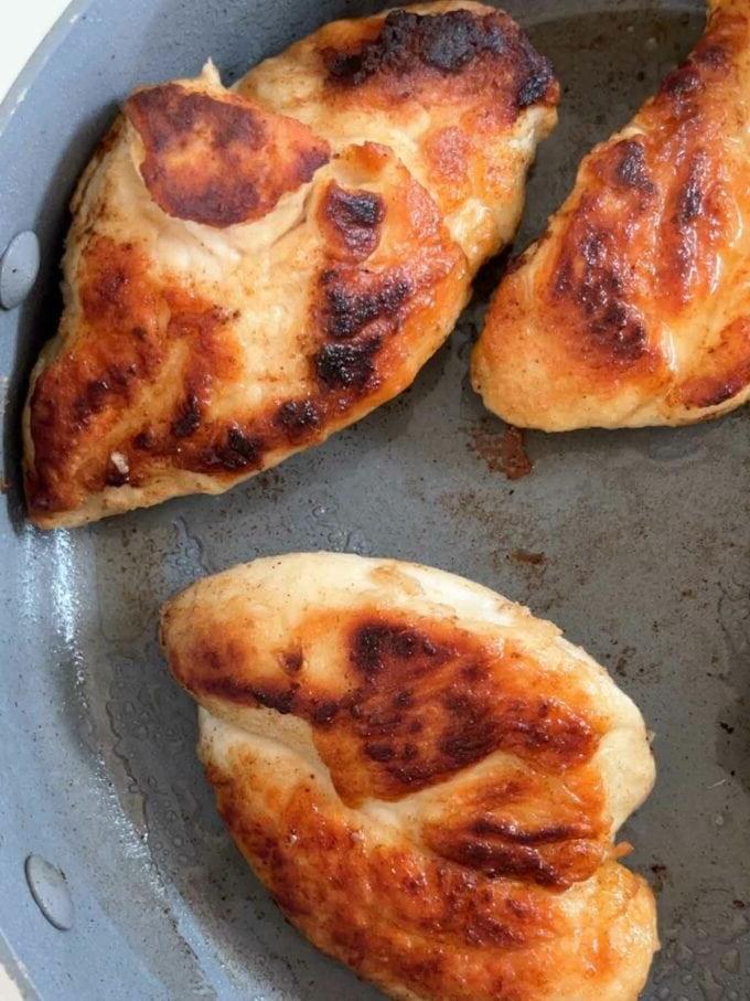 Petti di pollo che vengono rosolati in padella per la ricetta Pollo Sposami. Passaggio 2.