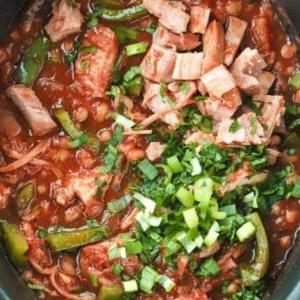 Facile Stufato da Falò {Ricetta per Pentola a Cottura Lenta} 6 Una pentola slow cooker piena di Stufato da Campo cotto e guarnita con cipollotti.