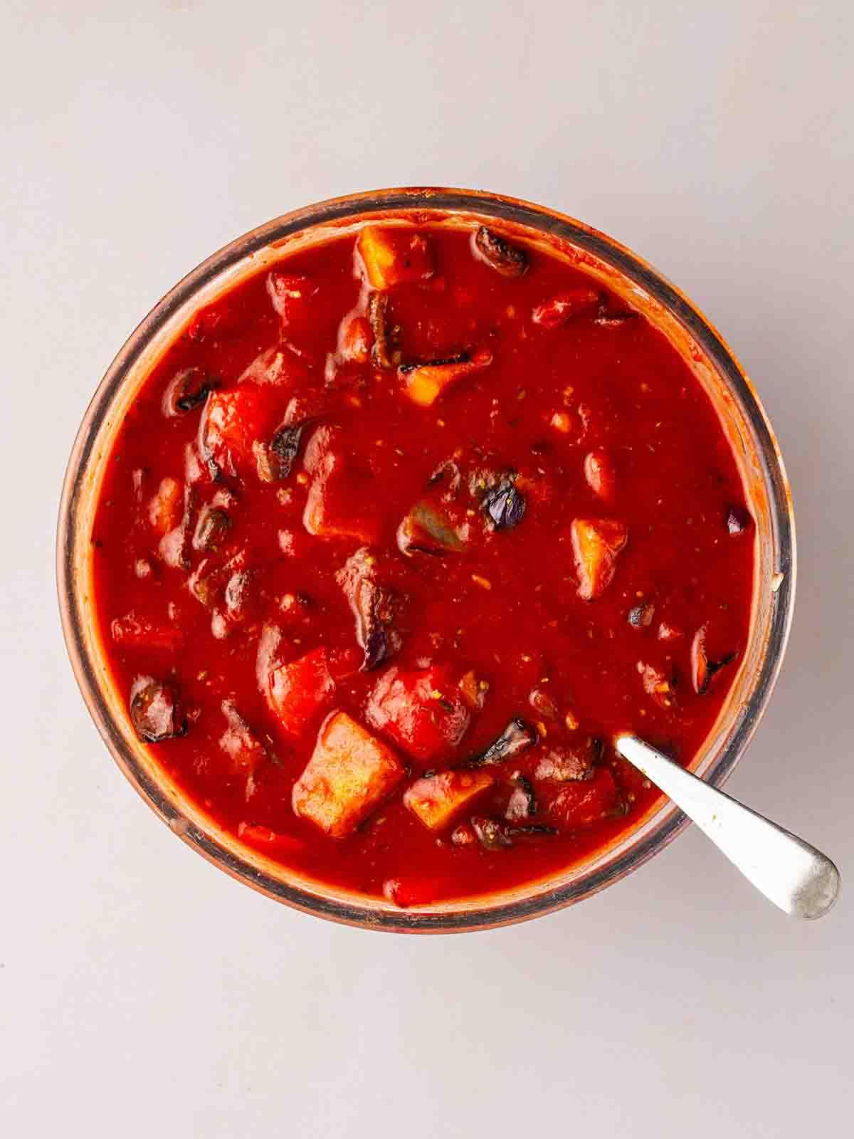 Enchiladas Vegetariane con Zucca Violina 6 Una ciotola piena di verdure arrosto e fagioli in salsa di pomodoro per il passaggio 2 della ricetta delle Enchiladas Vegetariane.