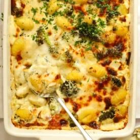 Piano Pasto 25 {Ricette Facili Infrasettimanali Vincenti} 6 Una pirofila piena di gnocchi al formaggio al forno con broccoli, e un cucchiaio pronto per servire.